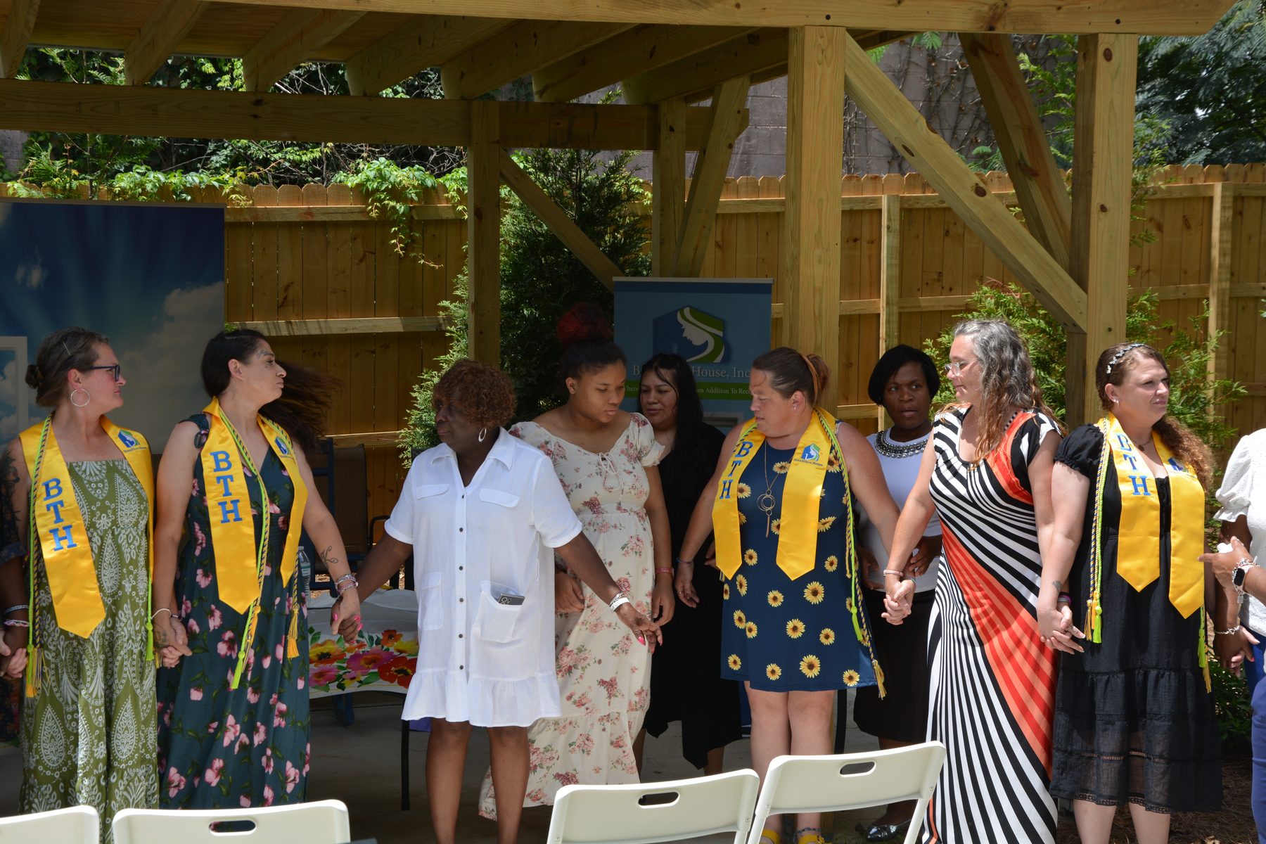 Graduates and staff joining hands together